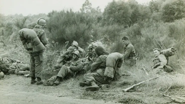 Militairen liggen langs de kant van de weg.