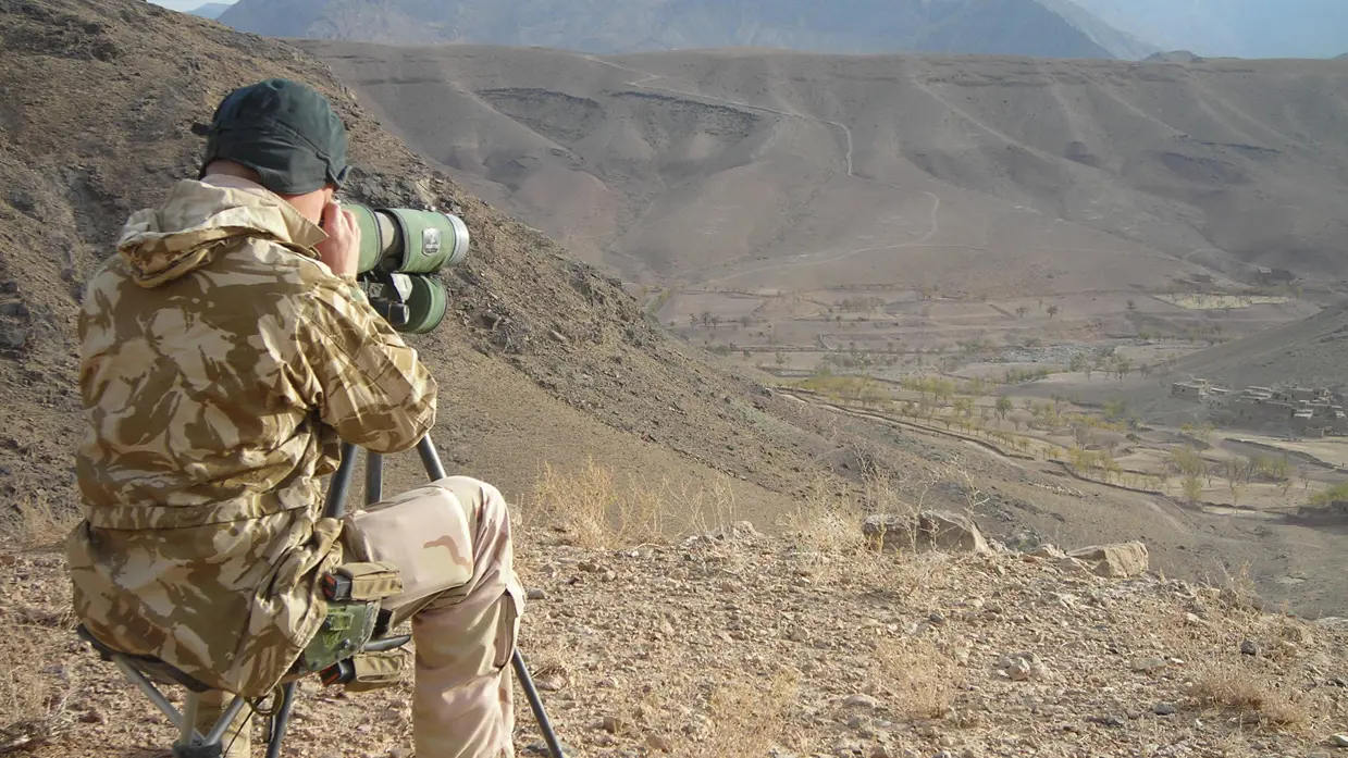 Militair kijkt door verrekijker.