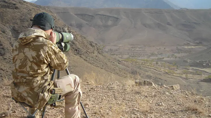 Militair kijkt door verrekijker.