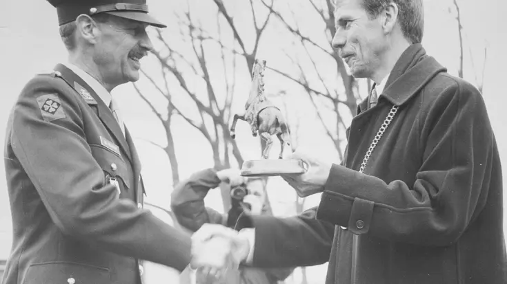 Burgemeester overhandigt een bronzen beeldje van een Fries veulen.