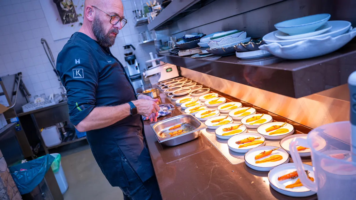 Kok in de keuken met bordjes eten voor zich