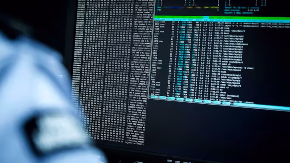 Een militair zit achter een beeldscherm waar gegevens op staan. 