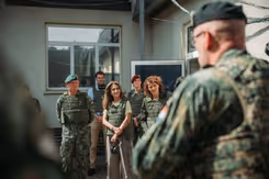 Ministers Yeşilgöz en Hermans in legervest luisteren naar militair.