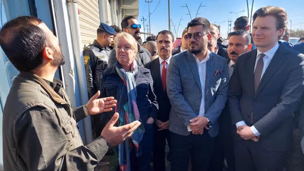 De minister luistert in Irak naar een man.