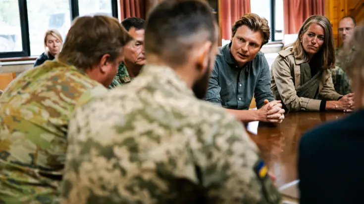 Minister Brekelmans aan tafel in overleg met militairen.
