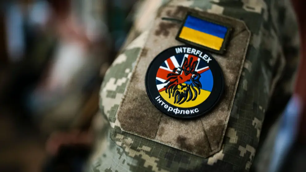 Patch van Operatie Interflex op mouw van militair.