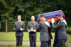 Militairen dragen de kist met het stoffelijk overschot.