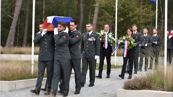 Militairen dragen een kist tijdens een herbegrafenis.