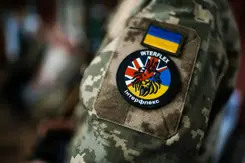 Patch van Operatie Interflex op mouw van militair.
