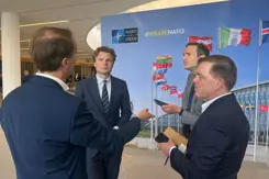 De minister in gesprek met journalisten.
