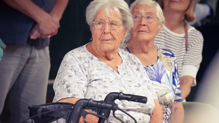 2 oudere dames kijken toe.