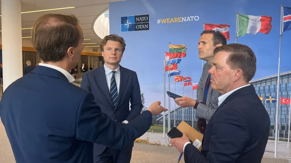 De minister in gesprek met journalisten.