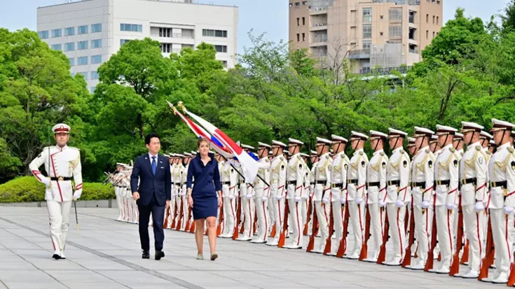 De ministers lopen langs Japanse militairen. 