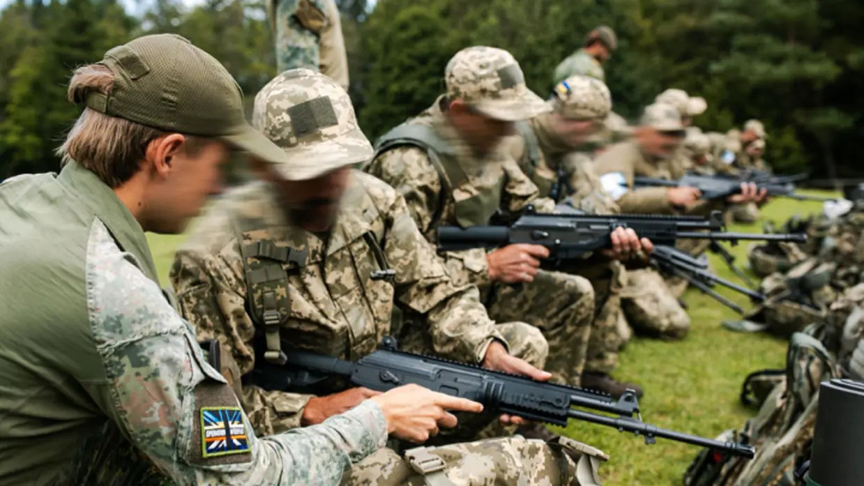Militairen krijgen uitleg op een lang wapen.