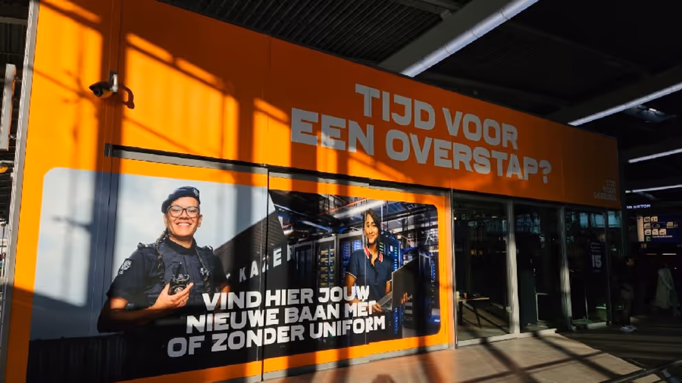 Grote oranje zuil en afbeelding van militairen. Tekst luidt: Tijd voor een overstap. Vind hier jouw baan met of zonder uniform.