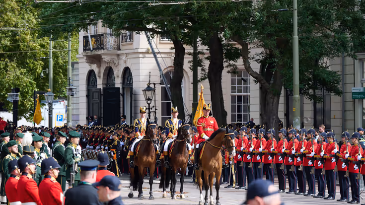 3 paarden geflankeerd door militairen. 