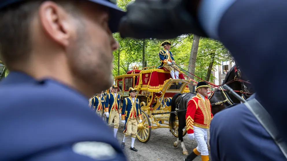 De Glazen Koets met op de voorgrond een saluerende militair