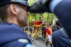 De Glazen Koets met op de voorgrond een saluerende militair