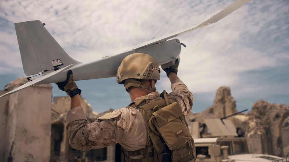 Militair houdt drone in de lucht.