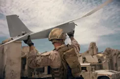 Militair houdt drone in de lucht.