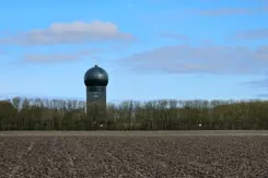 Het radarstation in Wier achter een rij kale bomen.
