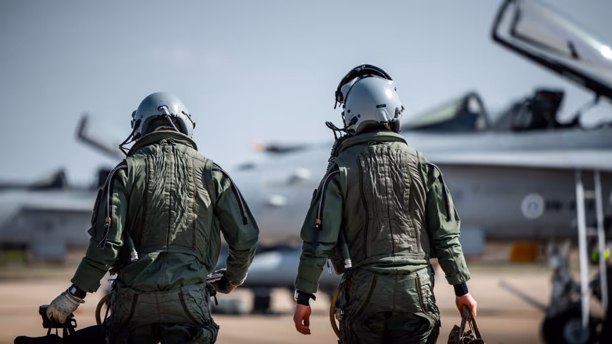 Vliegers lopen naar hun toestellen.