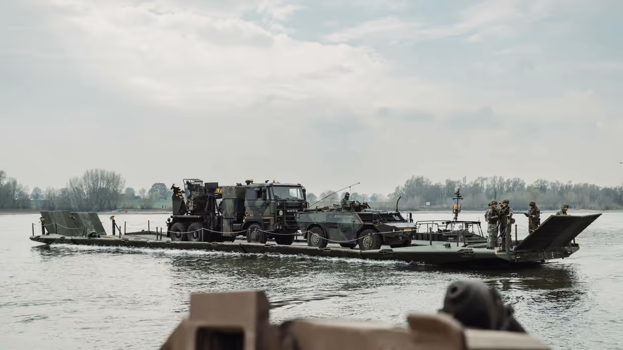 Ponton met vrachtwagen steekt rivier over.
