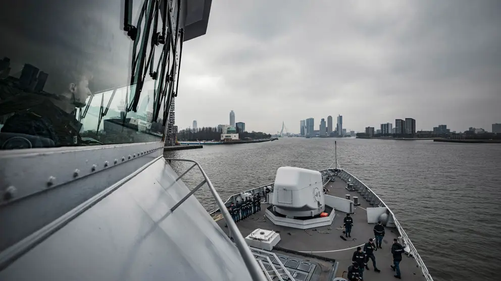 Marineschip vaart haven van Rotterdam binnen.