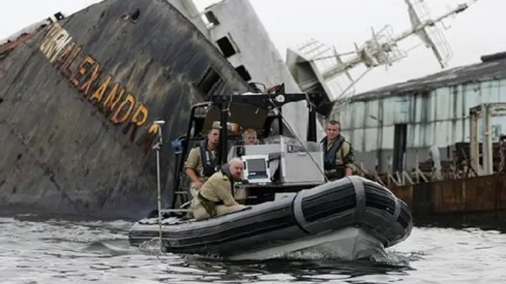Marinepersoneel met apparatuur in rubberboot.