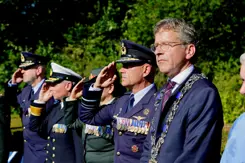 Militairen die salueren en de burgemeester van Eindhoven. 