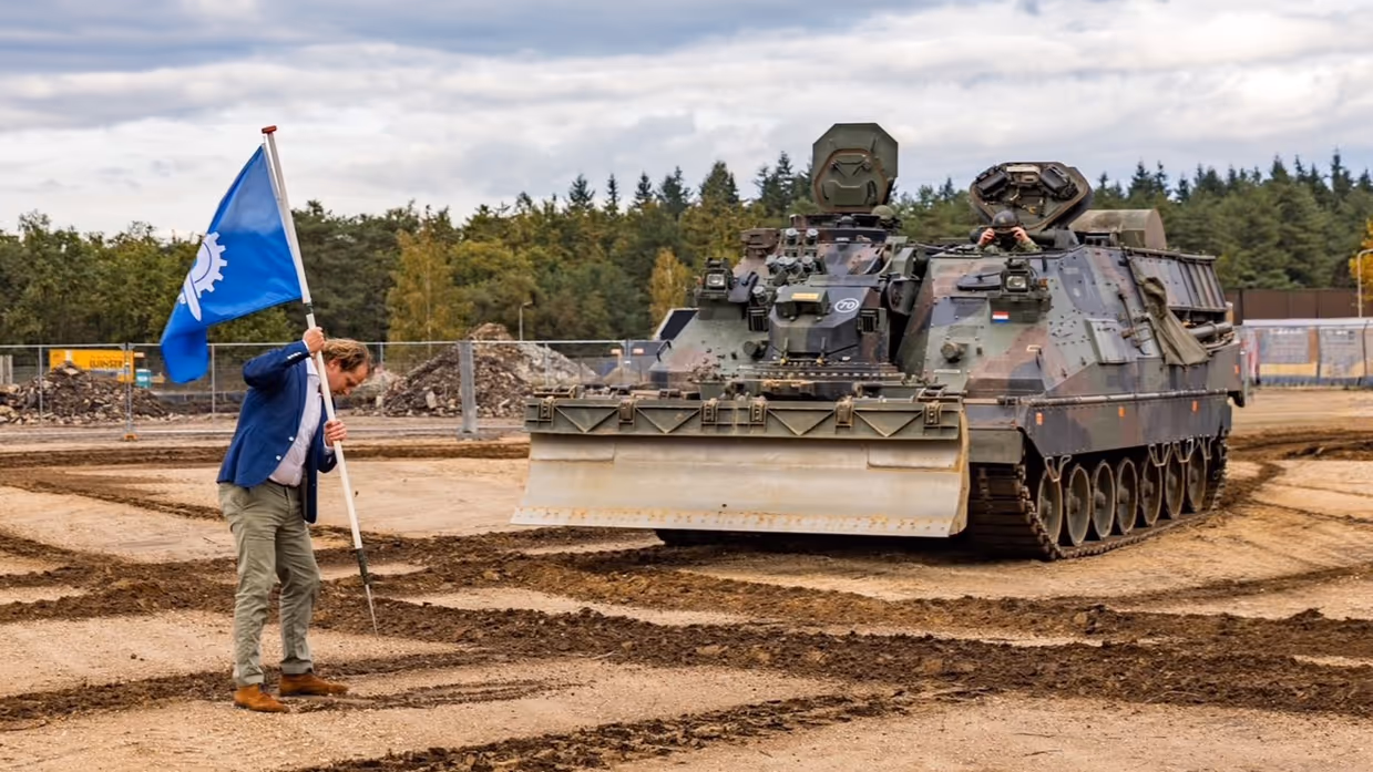 De staatssecretaris plant een vlag waar de Kodiak moet graven. 