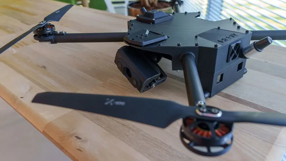 Innovatief apparaat met soort propellers op houten tafel.