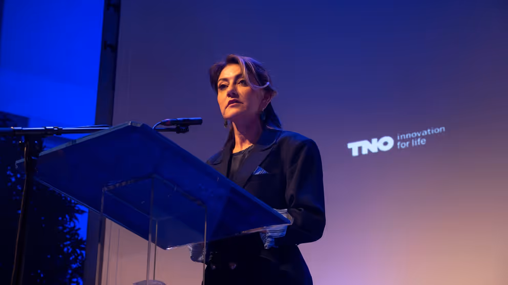 Minister Yeşilgöz staat achter het spreekgestoelte en houdt een speech.