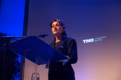 Minister Yeşilgöz staat achter het spreekgestoelte en houdt een speech.