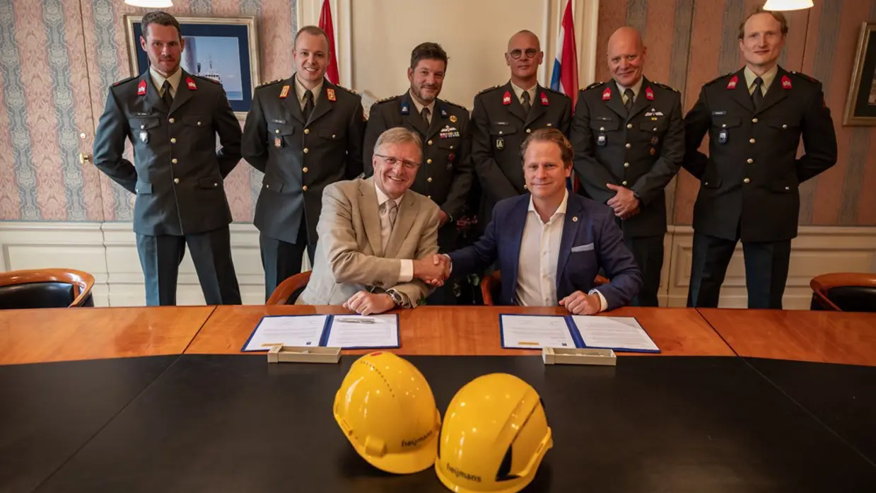 Staatssecretaris Gijs Tuinman geeft Heijmans een hand nadat ze de overeenkomst hebben getekend. 