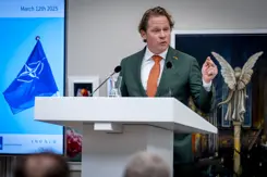 Staatssecretaris Gijs Tuinman staat achter een katheder.