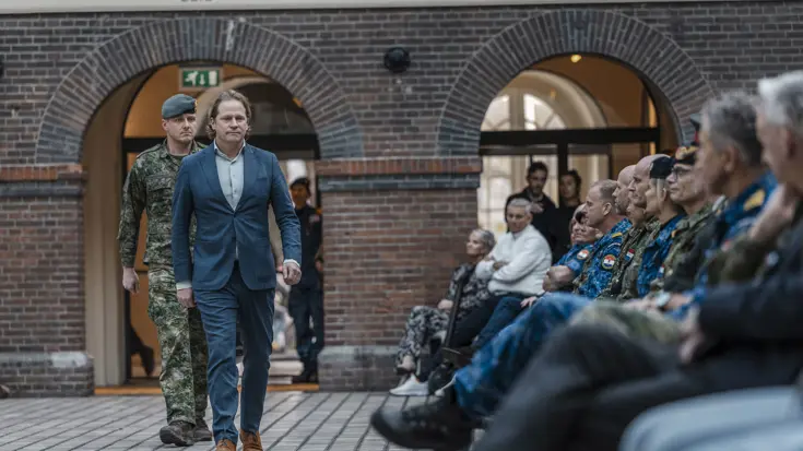 De staatssecretaris loopt langs de genodigden. 