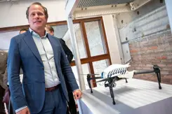 Staatssecretaris Tuinman staat naast een tentoongestelde drone.