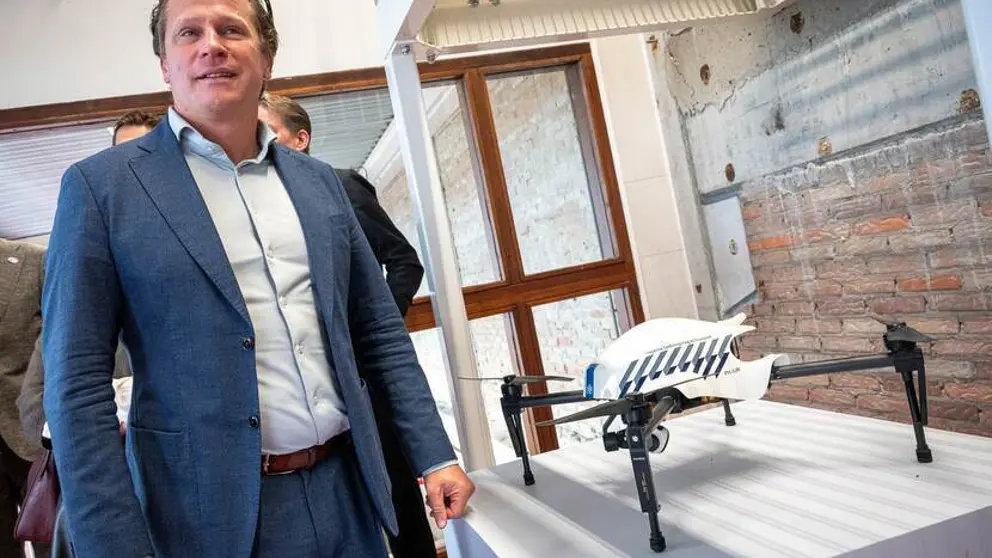Staatssecretaris Tuinman staat naast een tentoongestelde drone.