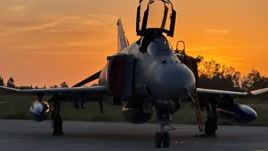 Een F-4 op de landingsbaan tegen de zonsondergang.
