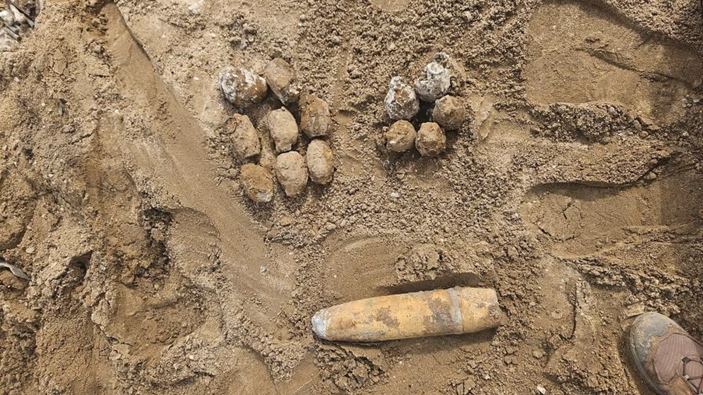 Projectielen liggen in het zand. 