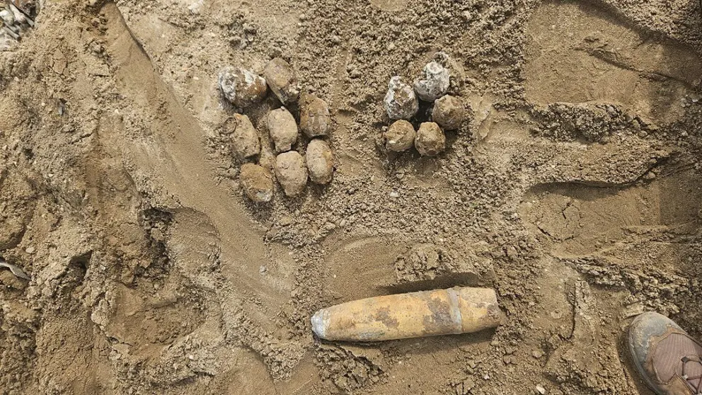 Projectielen liggen in het zand. 