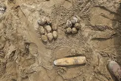 Projectielen liggen in het zand. 