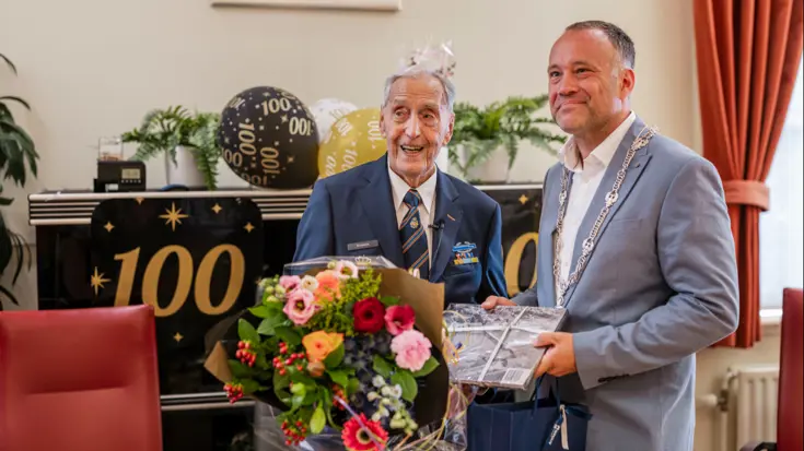 Ton Boelens krijgt een geschenk van loco-burgemeester Maarten van den Bos.