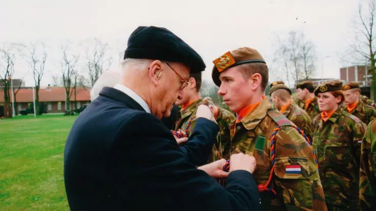 Militairen ontvangen het invasiekoord uit handen van een veteraan.