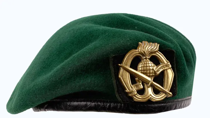 Groene baret met het embleem.