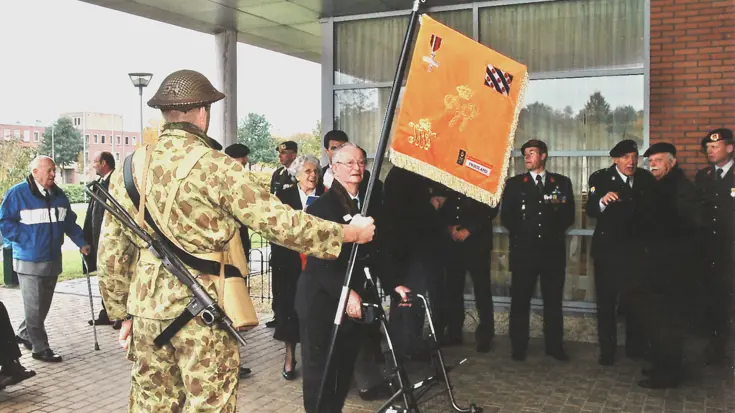 Militair draagt het vaandel van het Regiment Infanterie Johan Willem Friso.