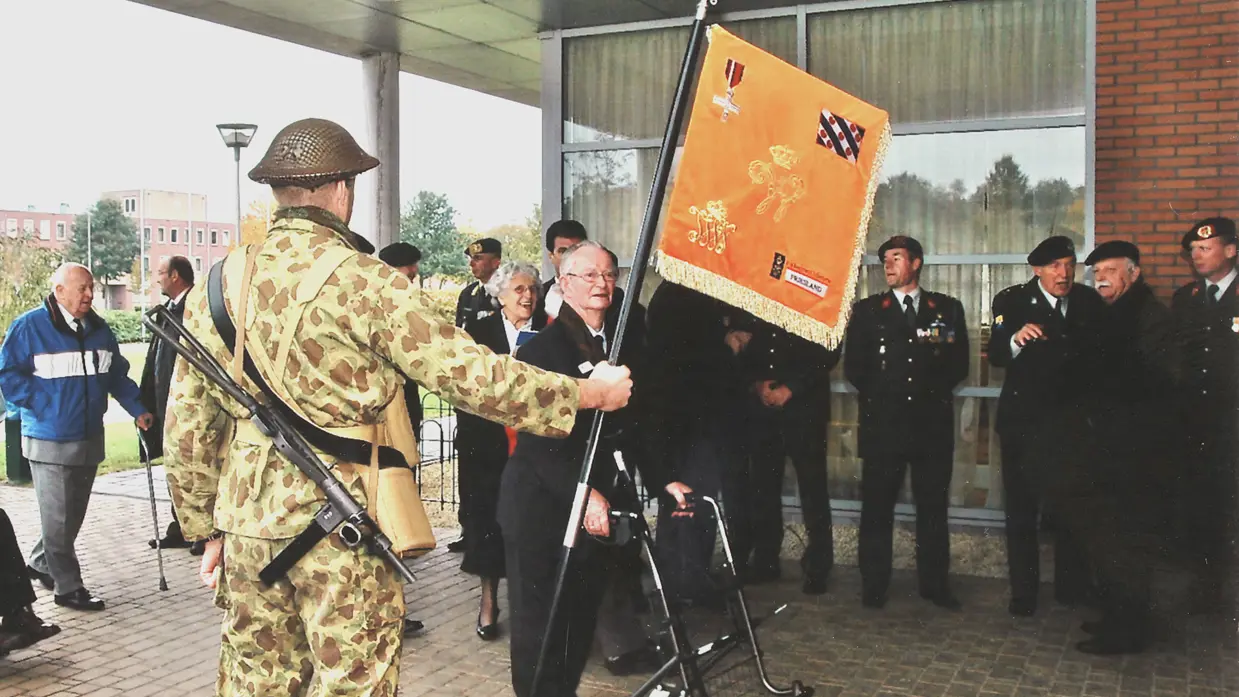 Militair draagt het vaandel van het Regiment Infanterie Johan Willem Friso.