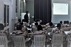 Klas Afrikaanse militairen op de rug gezien kijken naar een scherm.