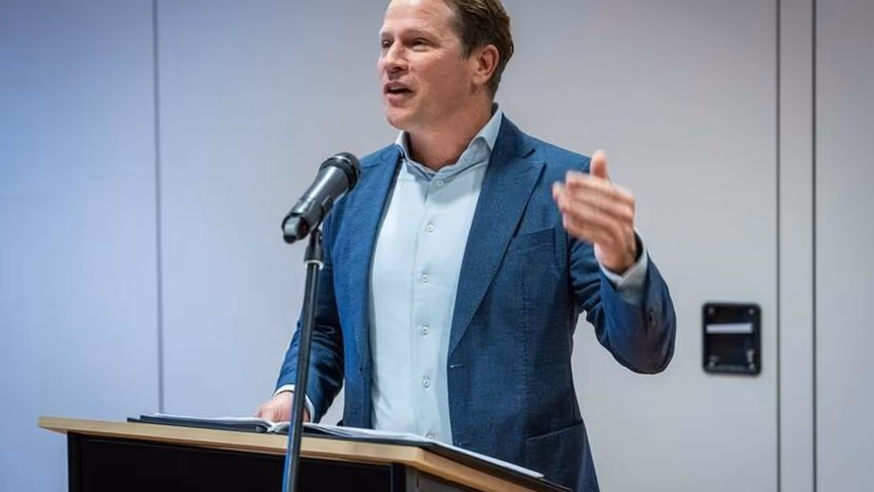 Staatssecretaris Gijs Tuinman staat achter een katheder.